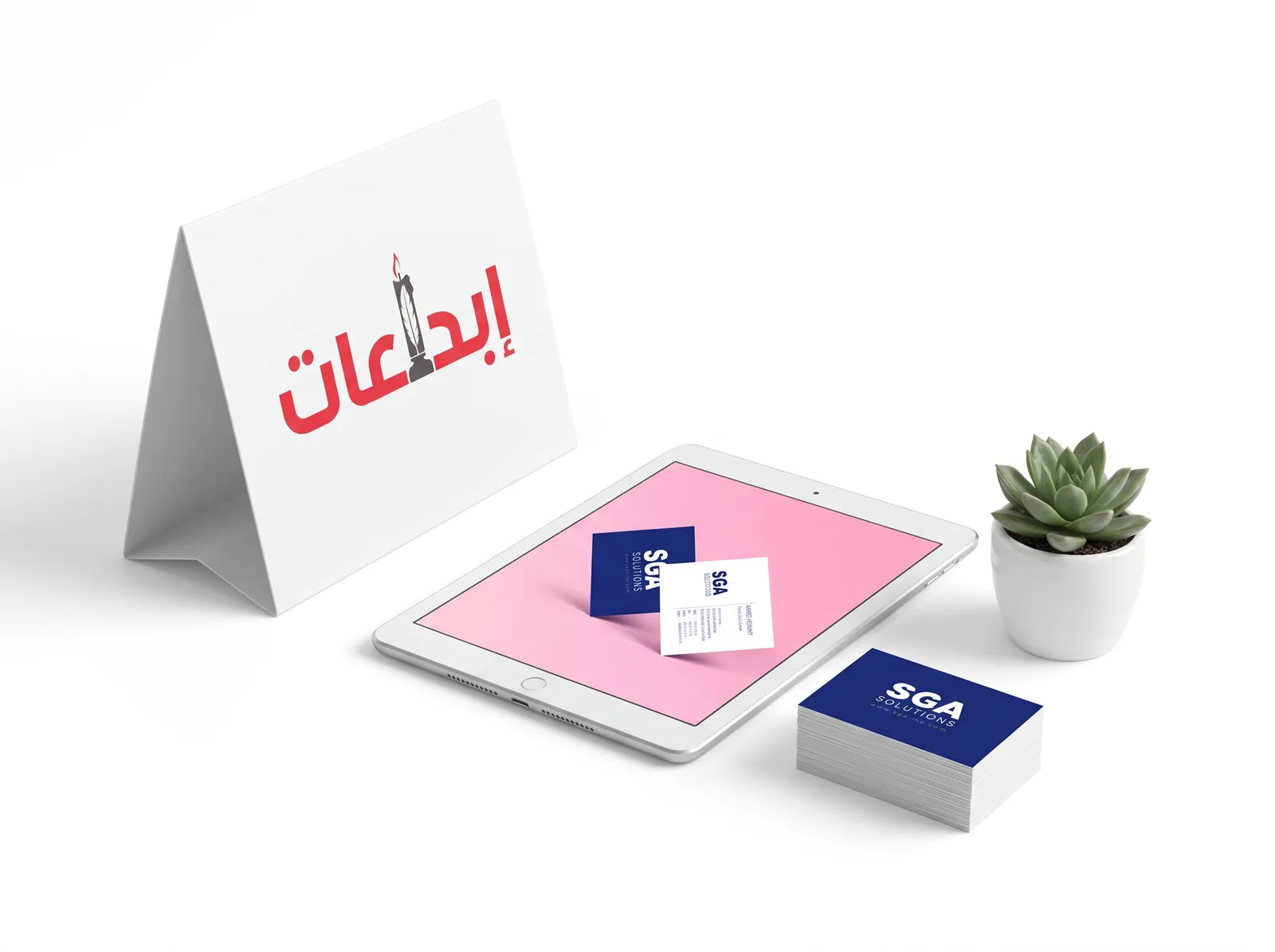 A display stand with the Ebdaat logo beside a tablet showing our work and business cards